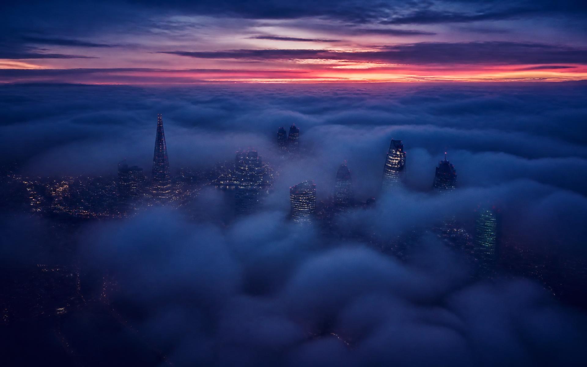 The City of London skyline emerging through cloud before sunrise